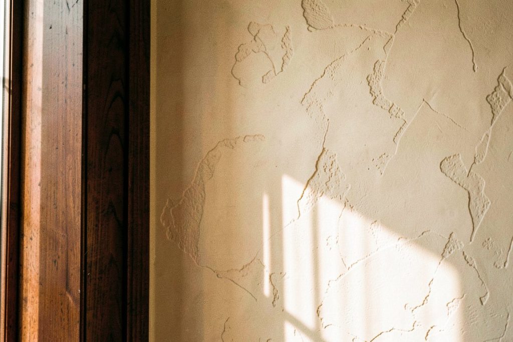 Venetian plaster wall in afternoon light beside a walnut door frame