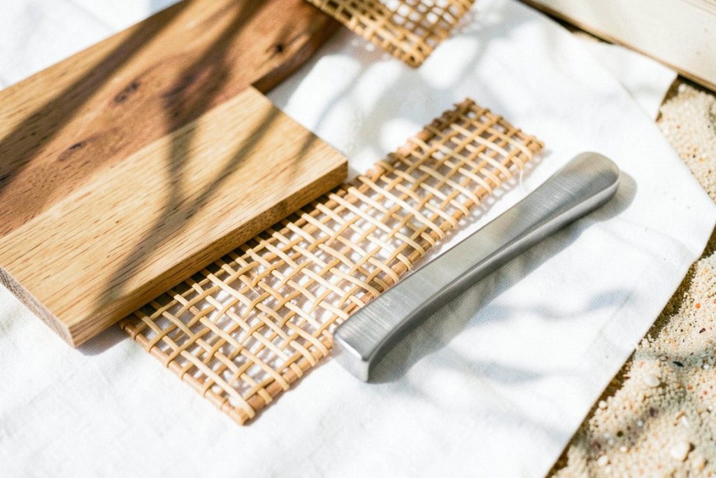 Teak, rattan and brushed steel samples on a linen table
