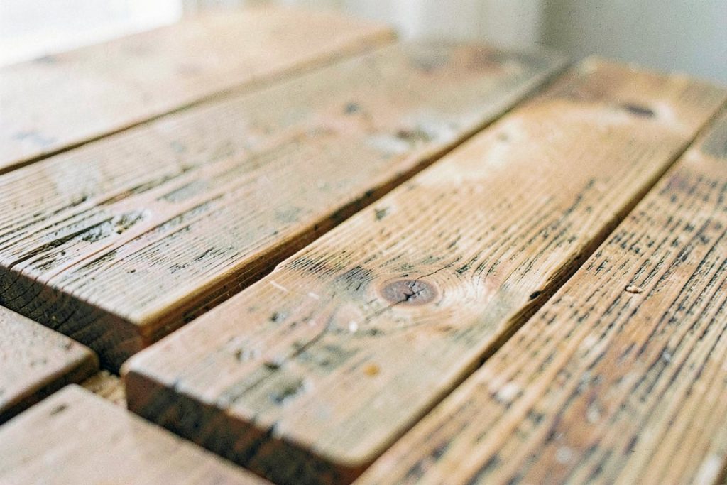 Planche de teck vieilli aux veines naturelles sous lumière douce